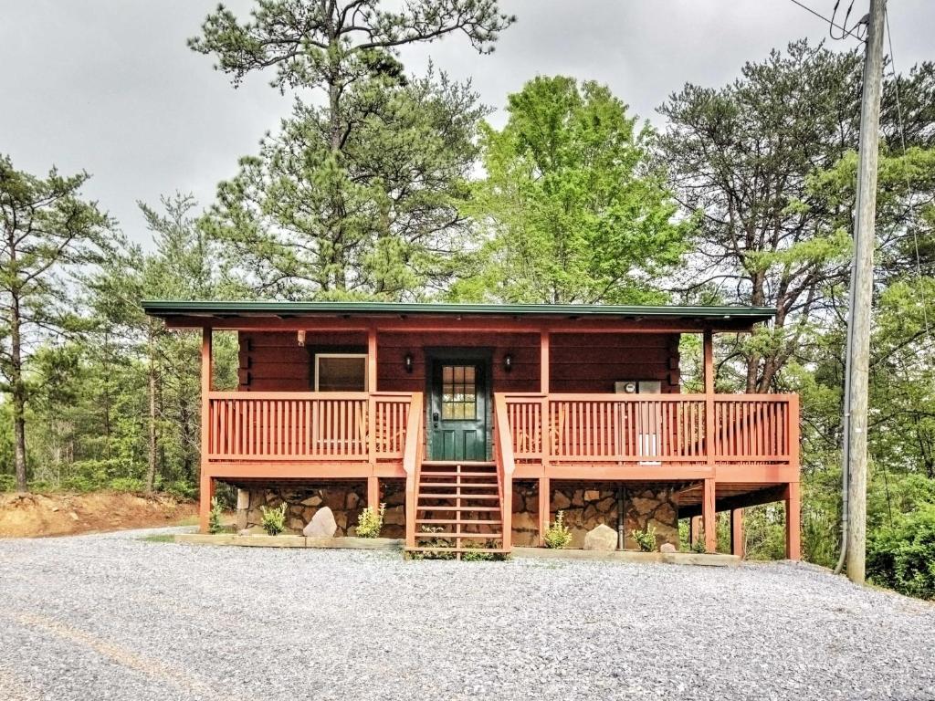 a cabin in the woods with a front porch and a deck at Log Cabin Studio in Sevierville with Deck and Hot Tub! in Sevierville