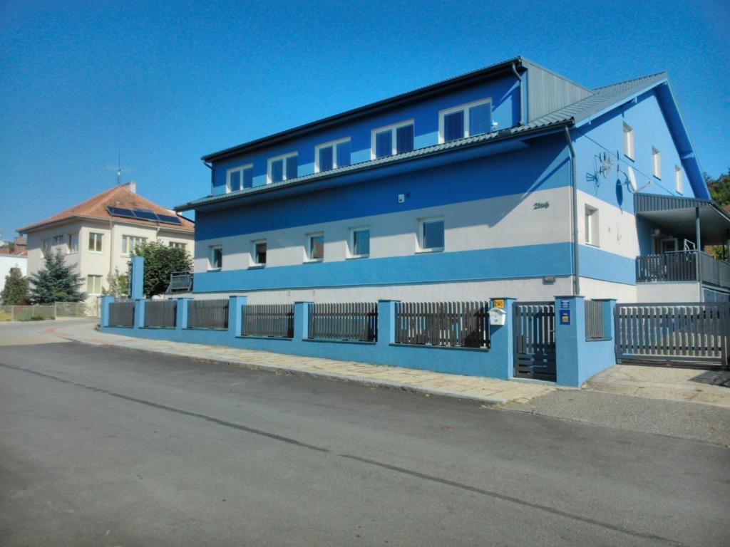 ein blau-weißes Gebäude an der Straßenseite in der Unterkunft Manhattan Penzion in Písek