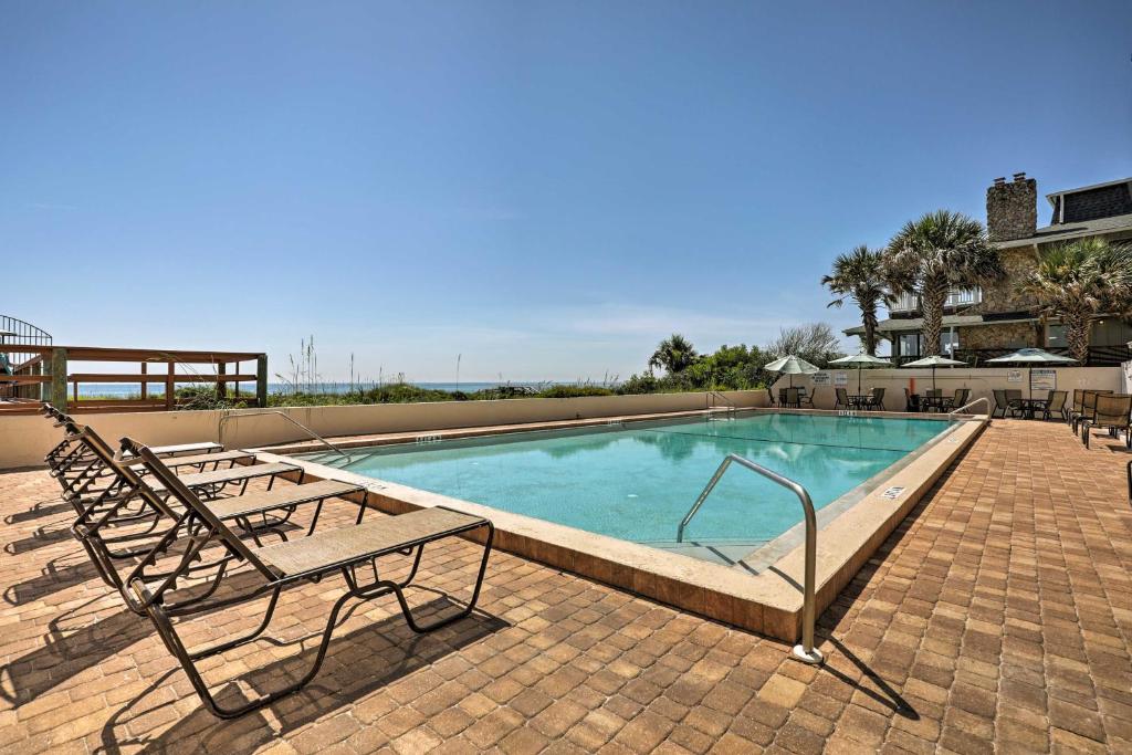 una piscina con due sedie e una panchina di Oceanfront St Augustine Studio with Pool Access! a St. Augustine