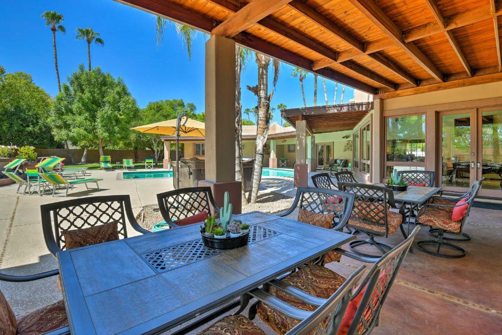 a patio with a blue table and chairs and a pool at ScottsdaleandParadise Valley Estate 2 Mi to Old Town in Scottsdale