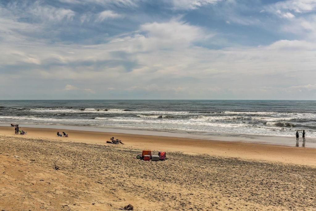 a beach with a group of people and the ocean at Outer Banks Island Cottage - 1 Mi to Frisco Beach! in Frisco