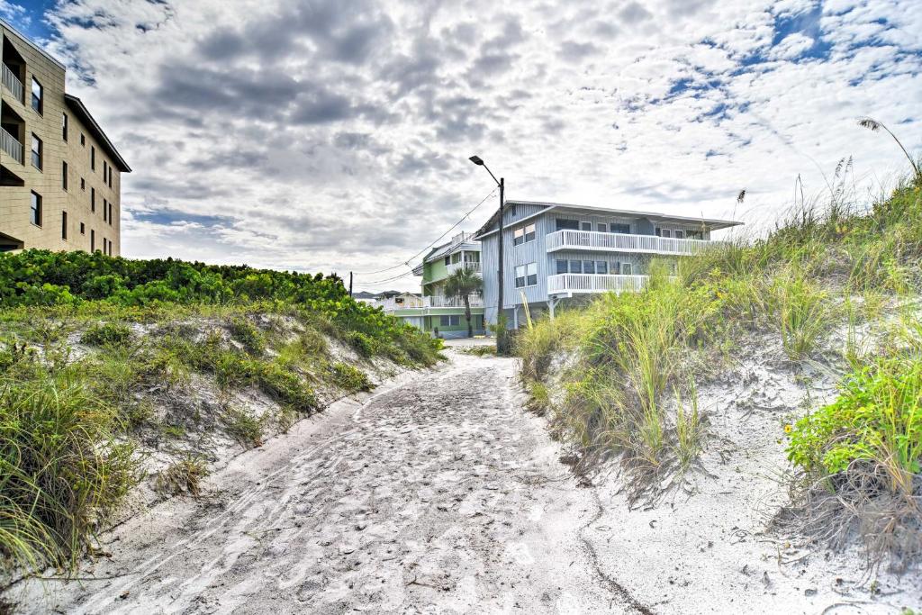 a dirt road leading to a building on a beach at Driftwood Beach Cottage - Walk to Clearwater Bch in Clearwater Beach