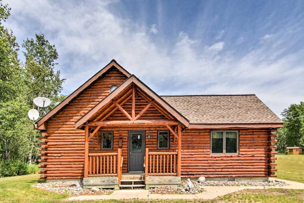 a log cabin with a porch and a door at Rapid River Log Cabin with Loft on 160 Scenic Acres! in Gladstone