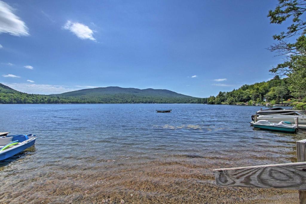 un cuerpo de agua con barcos en la costa en Rustic Lakefront Retreat with Shared Dock and Beach!, en Rumney