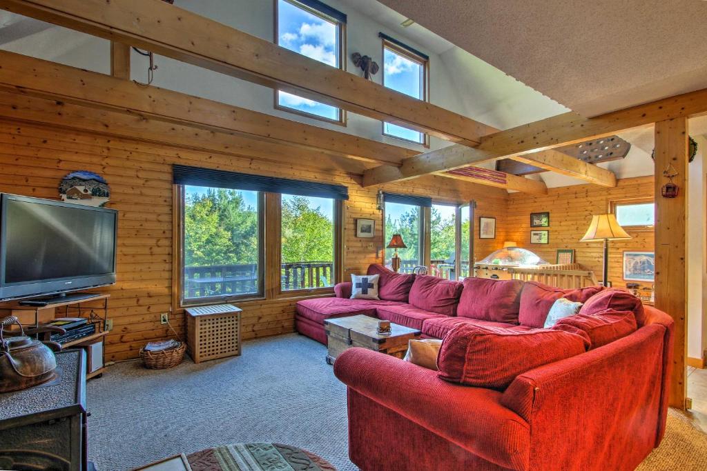 sala de estar con sofás rojos y TV de pantalla plana en Intervale Mtn Home with Sauna, 5 Mi to North Conway!, en Intervale