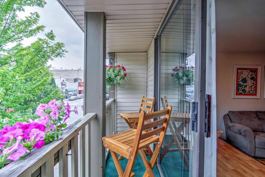 a balcony with a table and chairs and flowers at Downtown Grand Haven Apt Less Than 1 Mi to Lake Michigan in Grand Haven