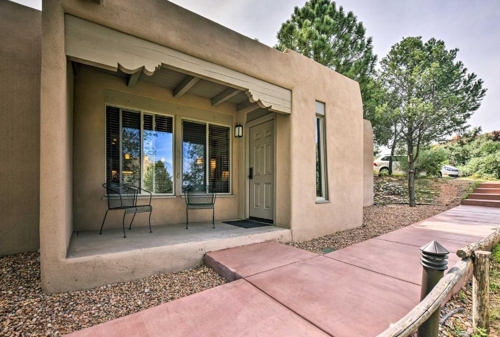 une maison avec 2 chaises sur la terrasse couverte à l'avant dans l'établissement Adobe-Style Abode with Amenities - Walk to Plaza!, à Santa Fe