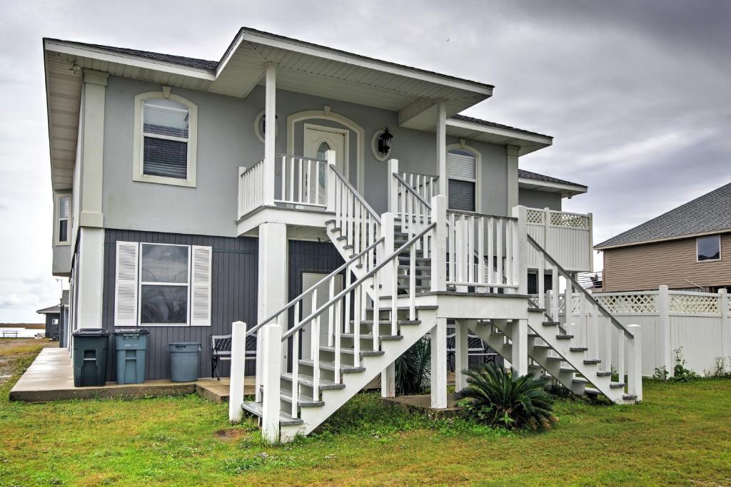 a house with a white staircase in front of it at Waterfront Slidell Home with Boat Dock and Canal View! in Slidell