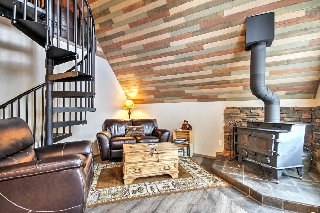 a living room with leather furniture and a fireplace at Hillside Cripple Creek Cabin with Hot Tub, Mtn Views! in Cripple Creek