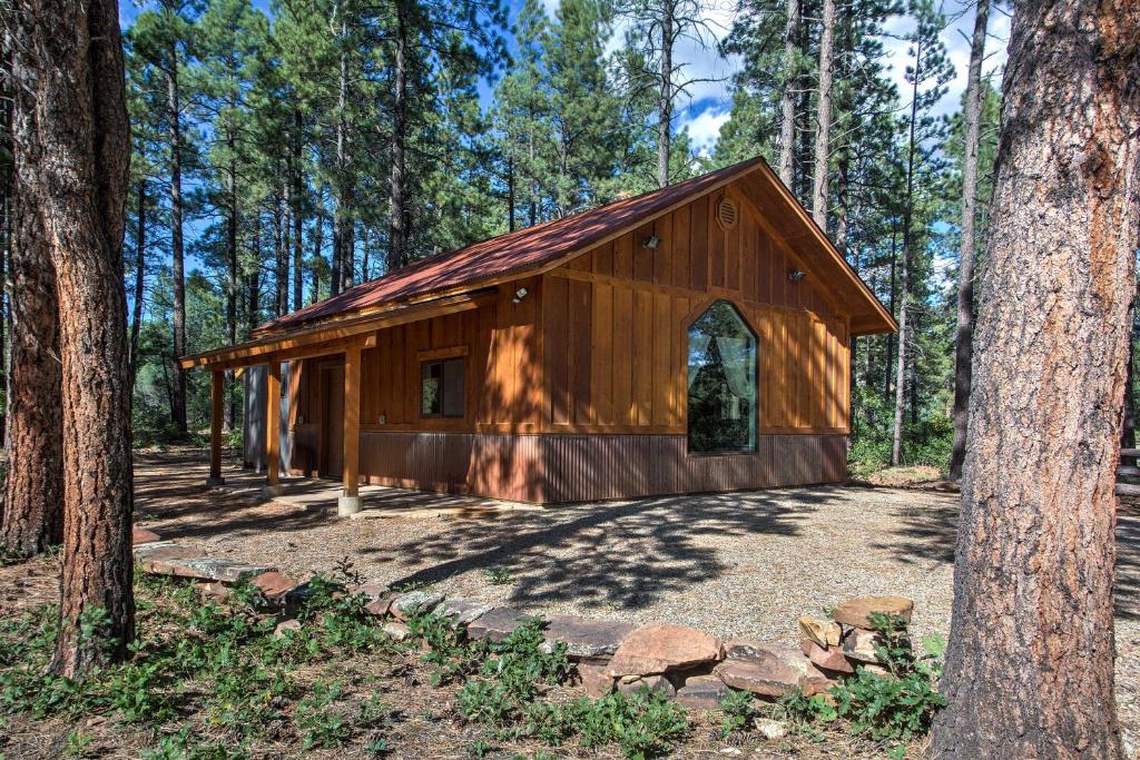 a small wooden cabin in the middle of a forest at Semi-Private Mancos Cabin on 80 Acres with Mtn View! in Dolores