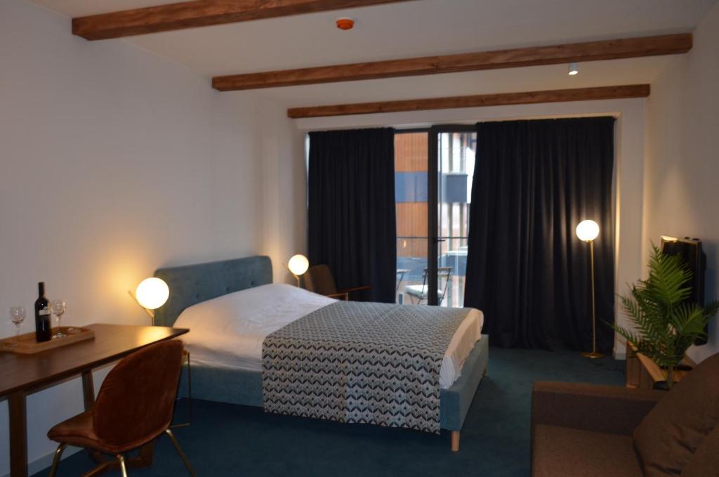 a hotel room with a bed and a desk and a window at Gudauri Atrium Redco in Gudauri