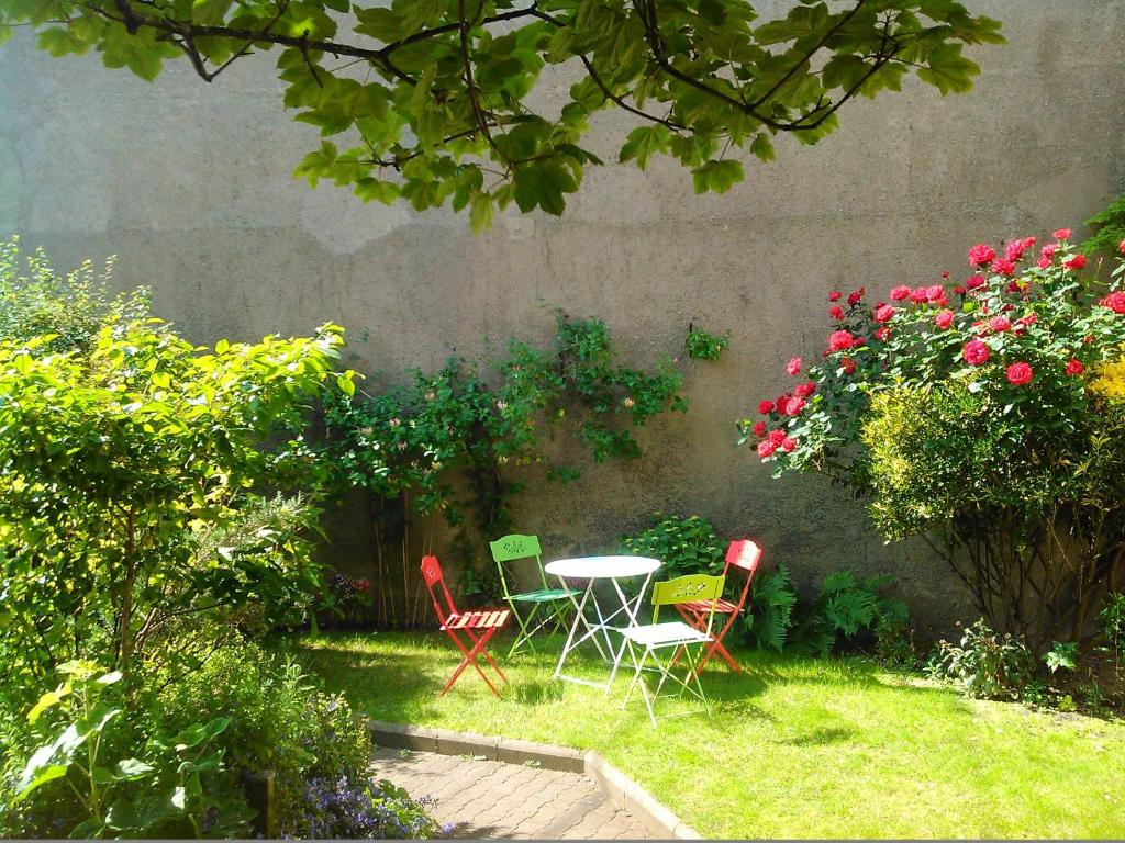 una mesa y sillas en un jardín con flores en Villa Les Palmiers, en Wimereux