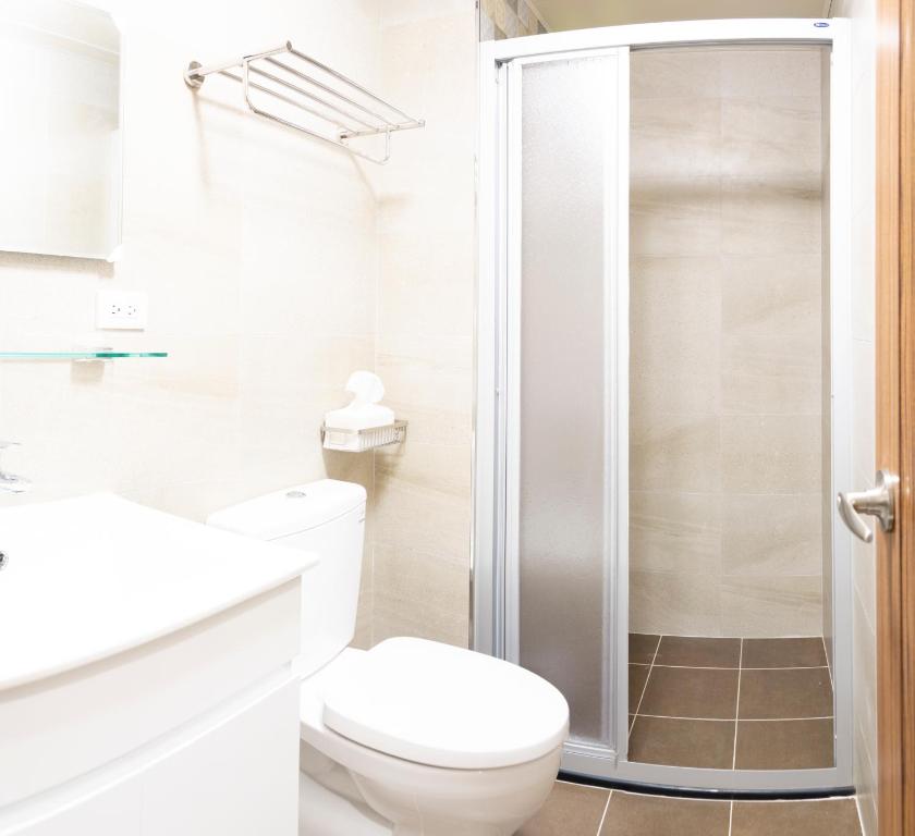 a white bathroom with a toilet and a shower at ioio in Tainan