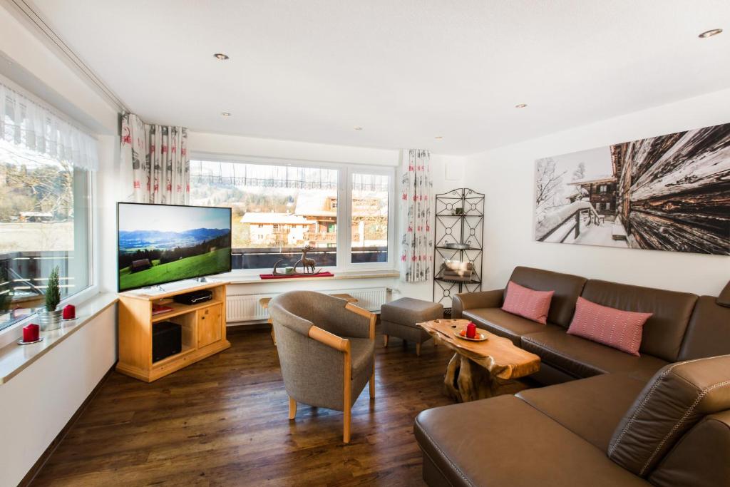 a living room with a couch and a flat screen tv at Ferienwohnungen Anger in Oberstdorf