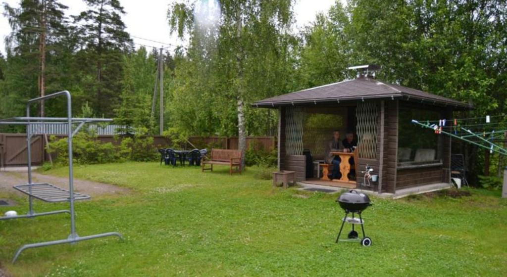 een tuinhuisje met een grill in een tuin bij Your Hotels in Nuppola
