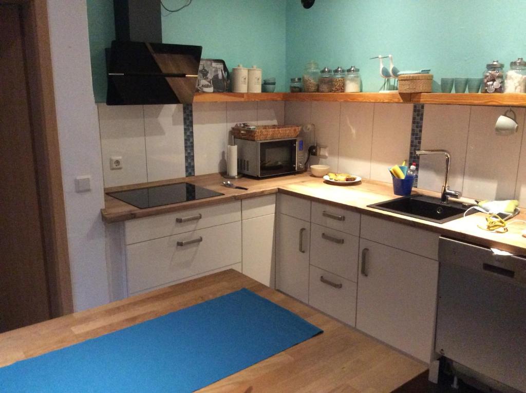 a kitchen with a blue rug on the floor at Lüttes Huus in Emden