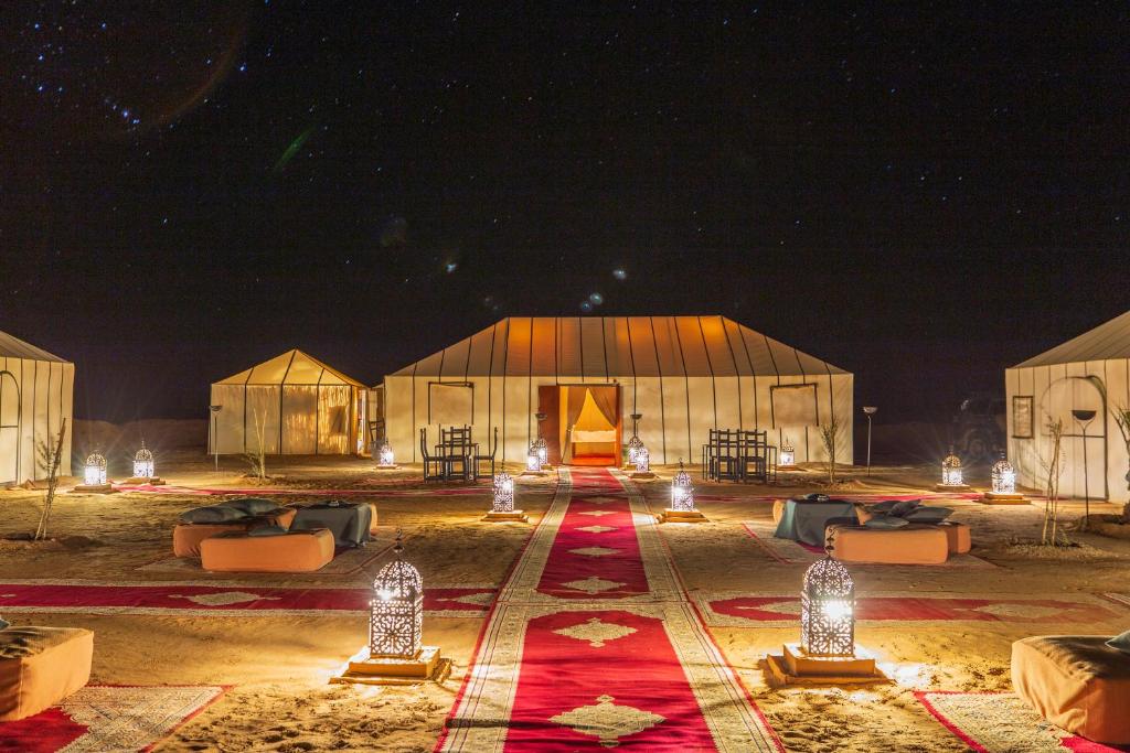 ein großes Gebäude mit Lichtern in der Nacht in der Unterkunft Sirocco Luxury Camp in Merzouga