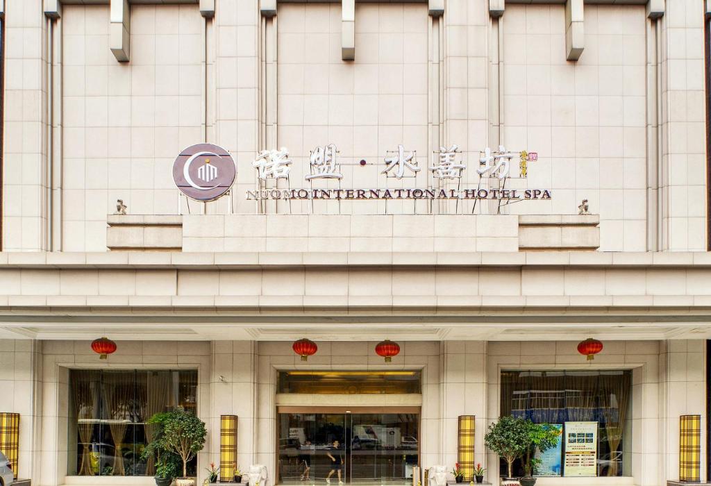 a building with a sign on the front of it at Guangzhou Nuomo International Hotel-Canton Fair Free Shuttle Bus in Guangzhou