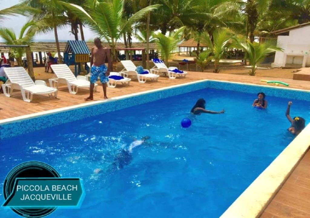 a group of people playing in the swimming pool at Piccola Beach in Sassako Bégniny