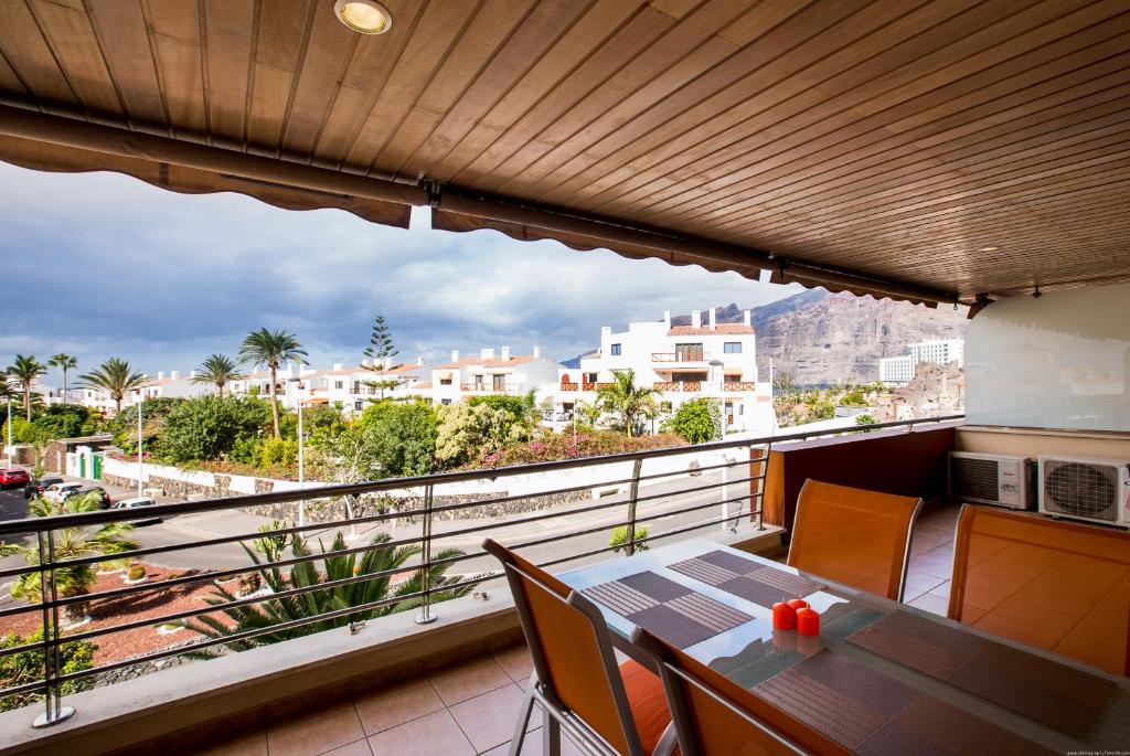 a balcony with a table and a view of the city at Apartamentos Balcon de Los Gigantes in Puerto de Santiago