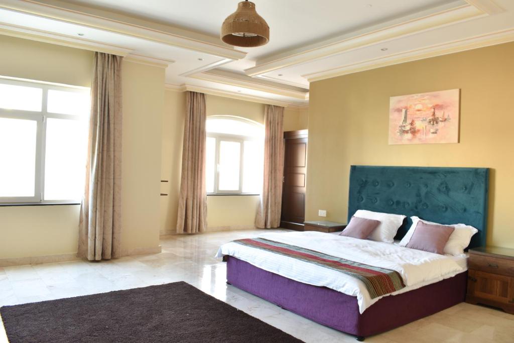 sypialnia z dużym łóżkiem z niebieskim zagłówkiem w obiekcie Muscat Villa w Maskacie