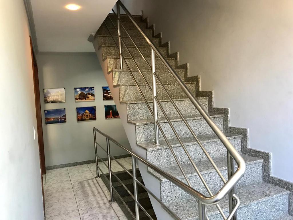 a staircase in a house with a metal railing at Regi House Hostel in Vitória