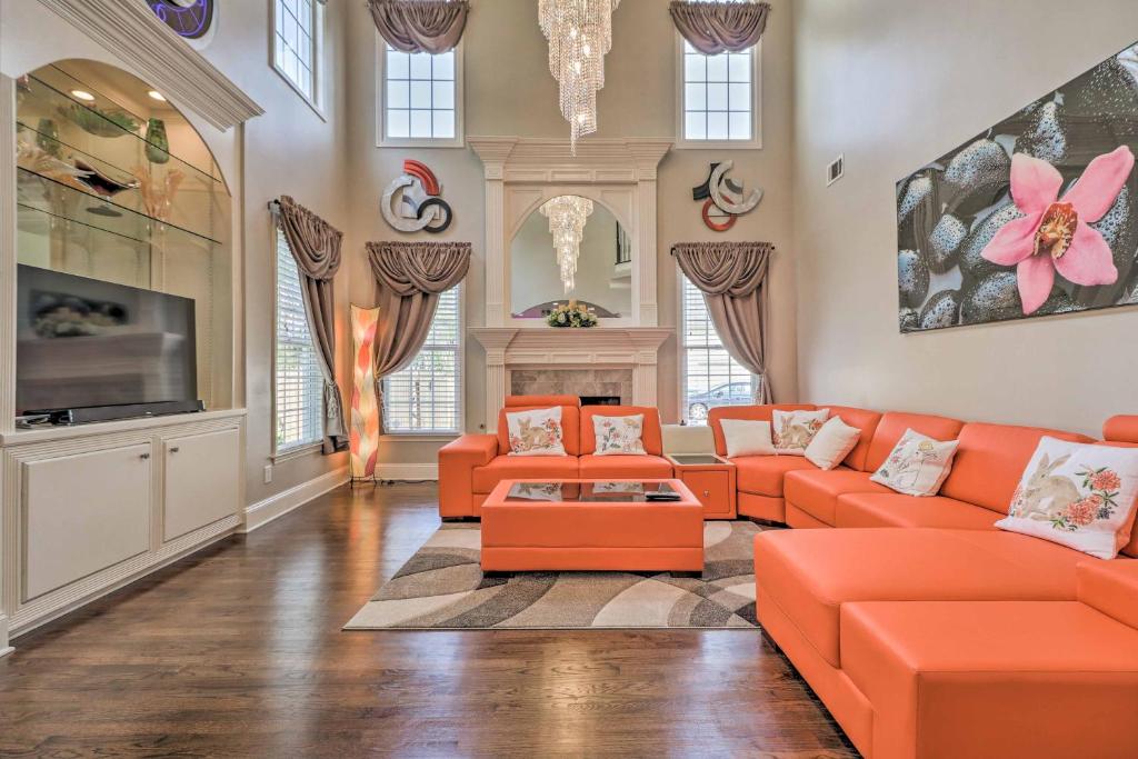 a living room with orange couches and a tv at Duluth Home with Patio 22 Mi to Downtown Atlanta! in Duluth