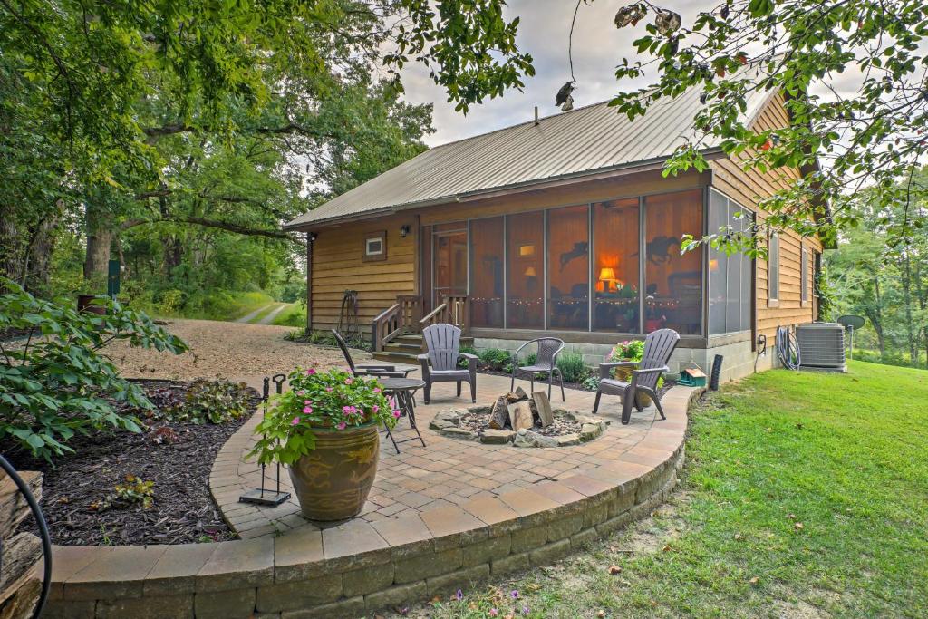 une cabane en rondins avec des chaises et un foyer extérieur dans la cour dans l'établissement Beautiful Makanda Cabin in Shawnee National Forest, à Makanda