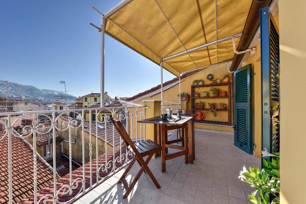 einen Balkon mit einem Tisch und einem Sonnenschirm in der Unterkunft Vienna's house in Lerici