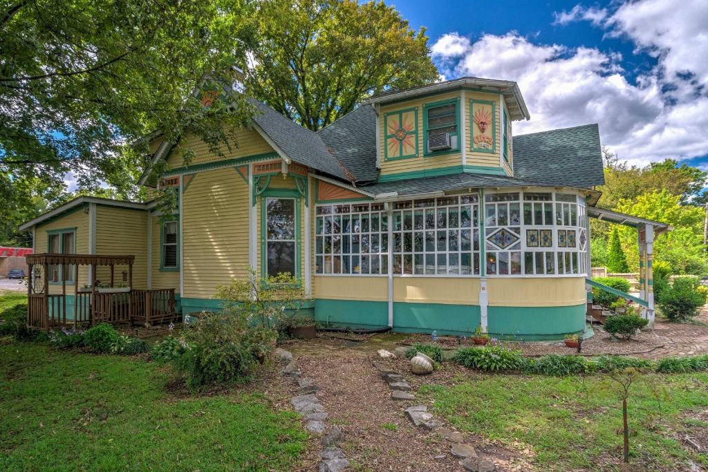 a yellow and green house with a porch at Russellville House with Garden - Walk to Main Street in Russellville