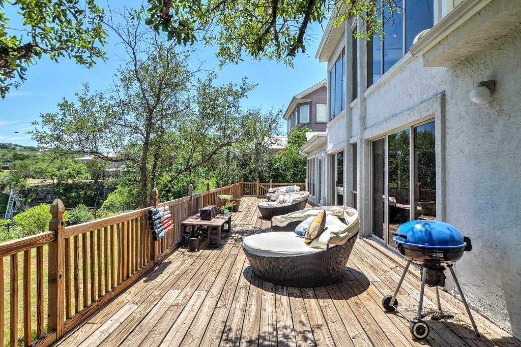 een houten terras met een bad en een grill erop bij Waterfront Lake Travis Luxury Home with Large Deck! in Spicewood