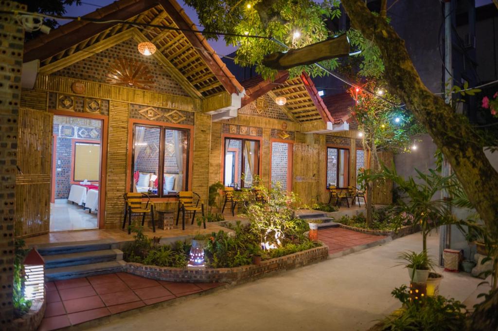 ein Holzhaus mit einer Terrasse und einem Tisch in der Unterkunft Tam Coc Three Princess Homestay in Ninh Bình