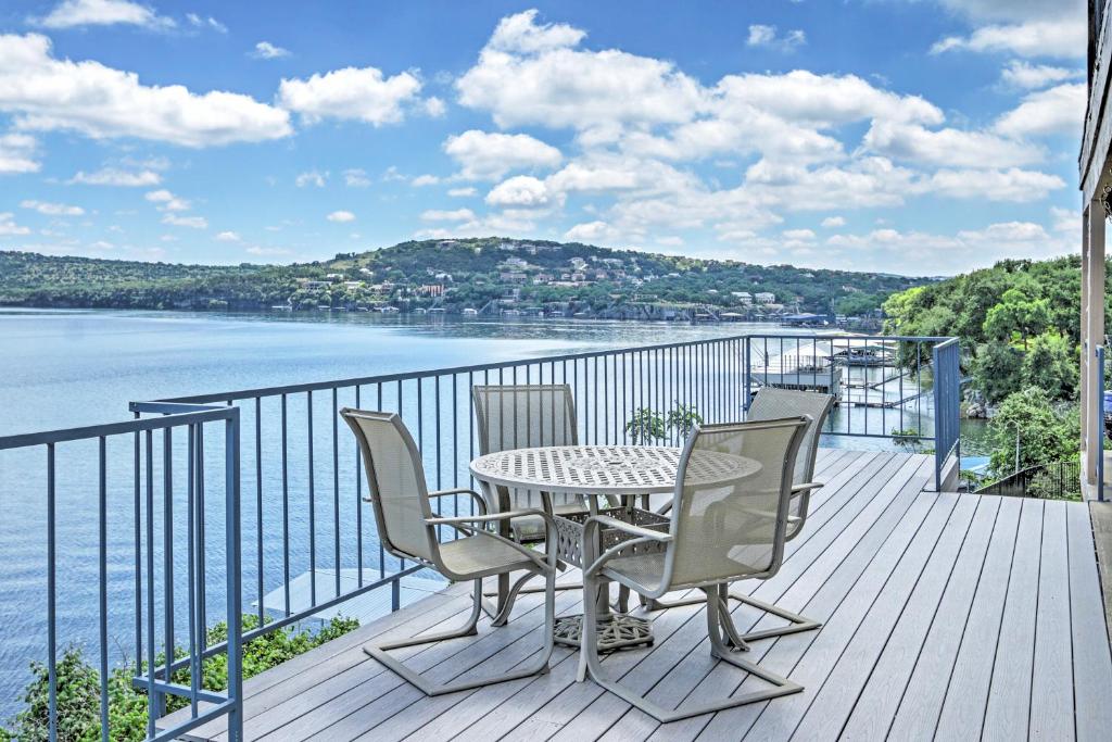 a table and chairs on a balcony with a view of the water at Spicewood Condo on The South Shore of Lake Travis! in Spicewood