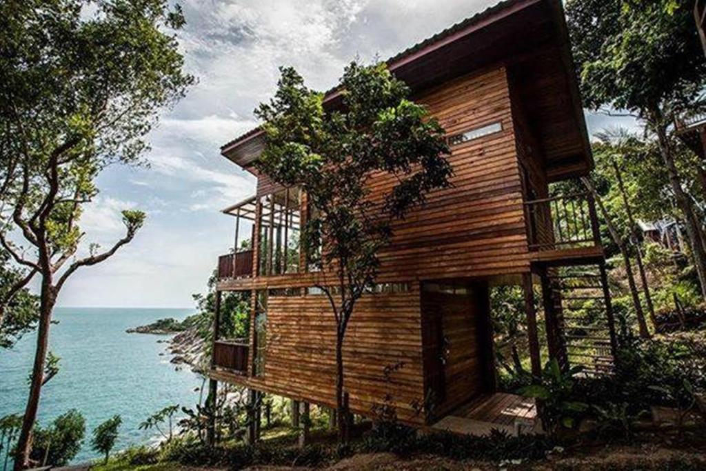 a wooden house on a hill next to the ocean at Amaresa Resort & Sky Bar - experience nature in Haad Rin