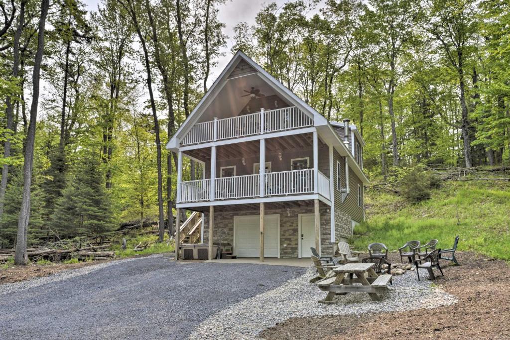 a house with a porch and picnic tables in front of it at Game Room and Hot Tub Old Forge Home! in Old Forge