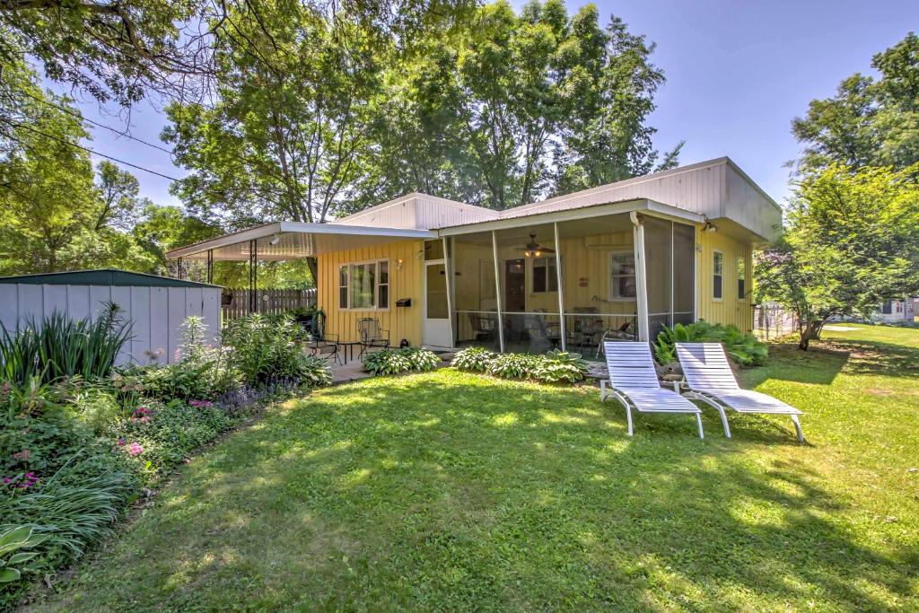 une maison avec deux chaises dans la cour dans l'établissement Spruce Haven Cottage Walk to Mississippi River!, à Bellevue