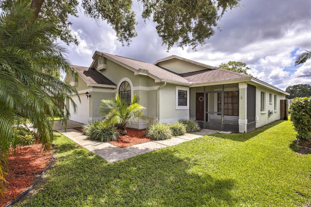 a house with a palm tree in front of it at Lakefront Brandon Home with Patio and Screened Lanai! in Brandon