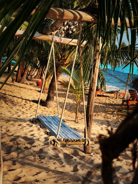 a swing on a beach with the ocean at Vung Bau Resort in Phú Quốc