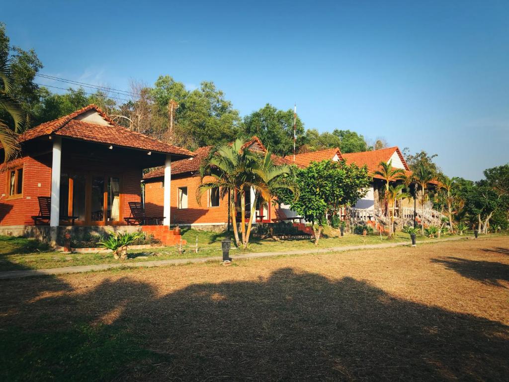 a house with a palm tree in front of it at Vung Bau Resort in Phú Quốc