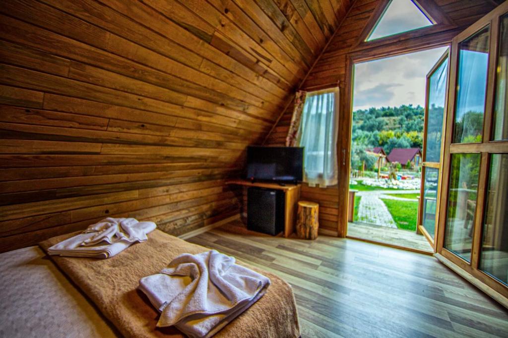 um quarto com uma cama e uma grande janela em Kazdaglari Ida Natura Bungalov Hotel em Akçay