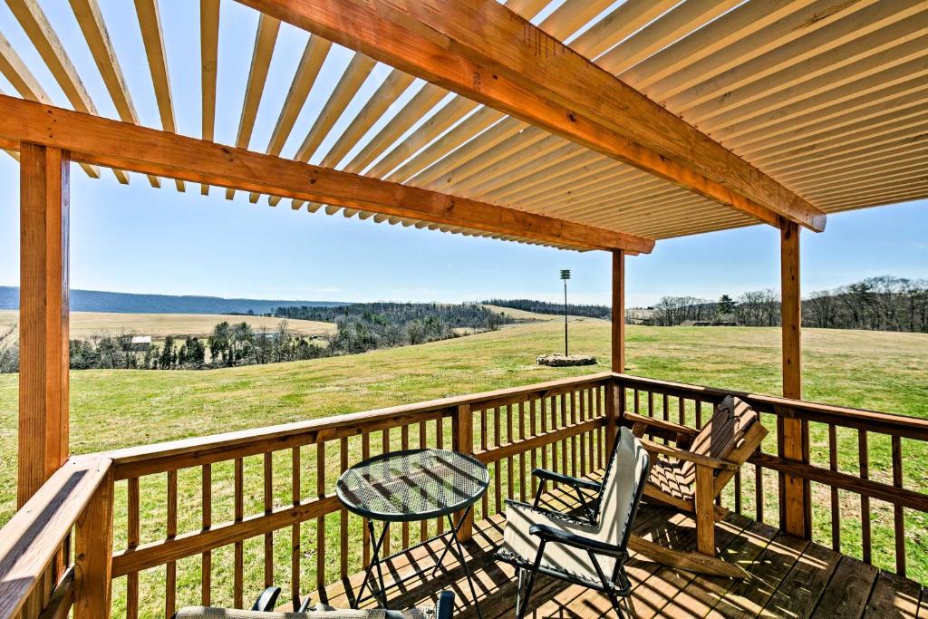 Klingerstown的住宿－The Lodge Klingerstown Home on 180-Acre Farm!，一个带椅子和桌子的门廊,享有田野的景色