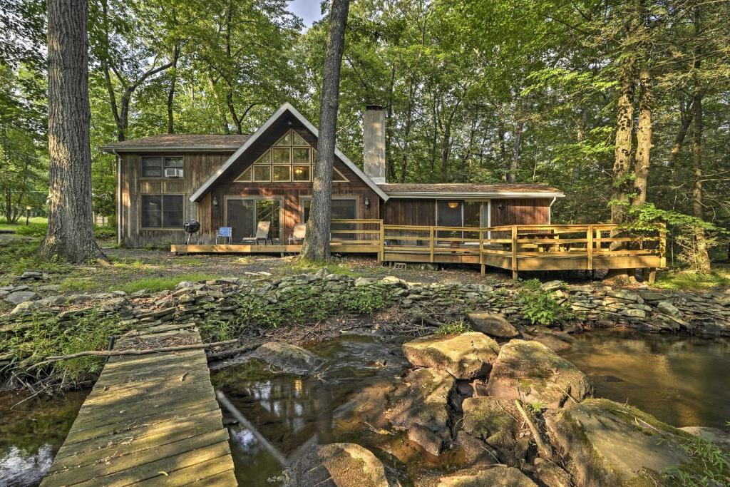 una baita di tronchi nel bosco vicino a un fiume di Secluded Stroudsburg Home with Deck, Grill and Stream! a Stroudsburg