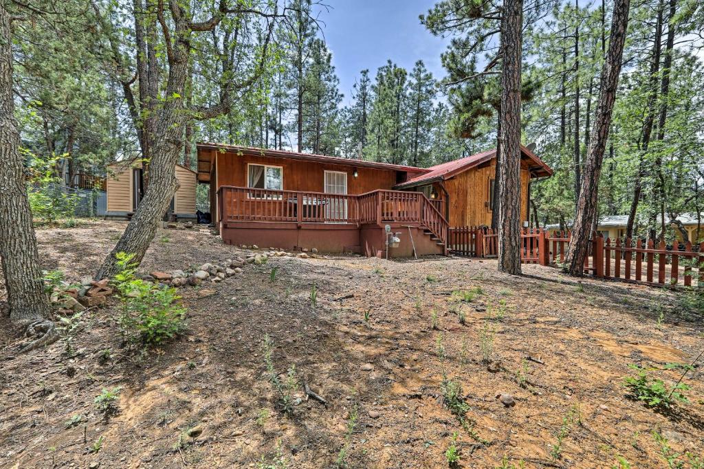 a log cabin in the woods with a yard at Cozy Lakeside Escape with Deck 4 Mi to Rainbow Lake in Pinetop-Lakeside