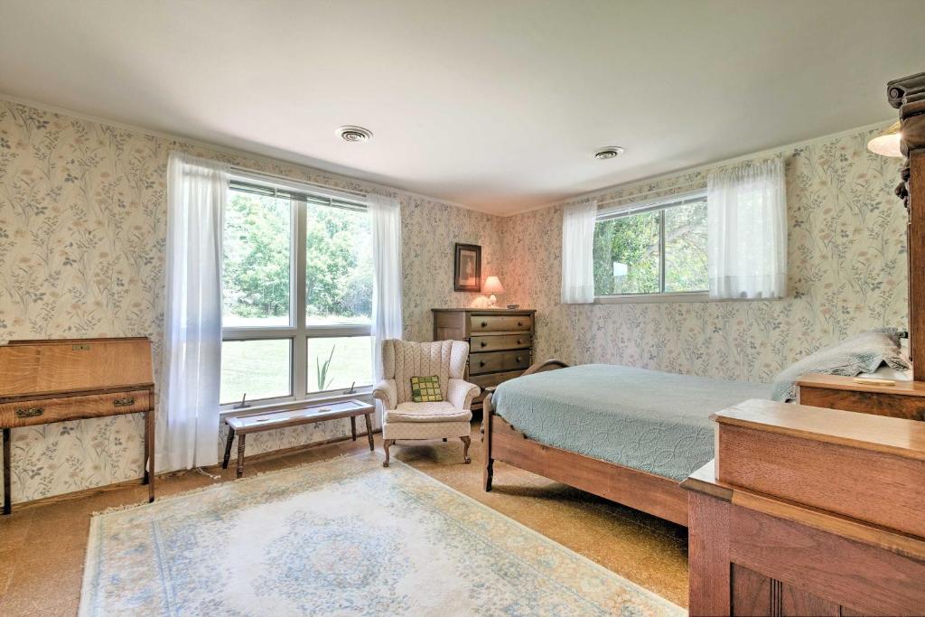 a bedroom with a bed and a chair and windows at Stair-Free Lexington Home with Blue Ridge Mtn Views! in Lexington