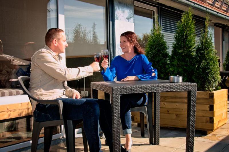 a man and woman sitting at a table drinking wine at Stadl Appartements in Türkheim