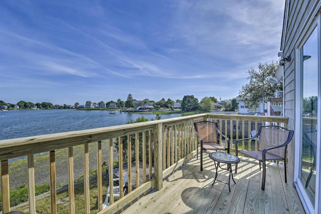 a balcony with two chairs and a view of the water at Coastal Rhode Island Home with Kayaks, Deck and Grill! in Portsmouth