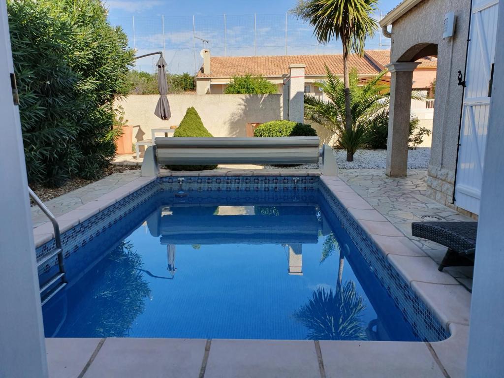 - une piscine d'eau bleue dans la cour dans l'établissement Lieblingshaus, à Portiragnes