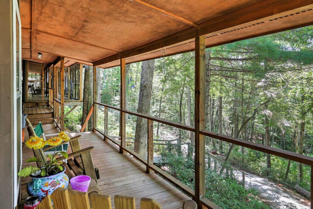 a screened in porch with a view of the woods at Lakefront Mountain Rest Cottage with Gas Fireplace! in Walhalla