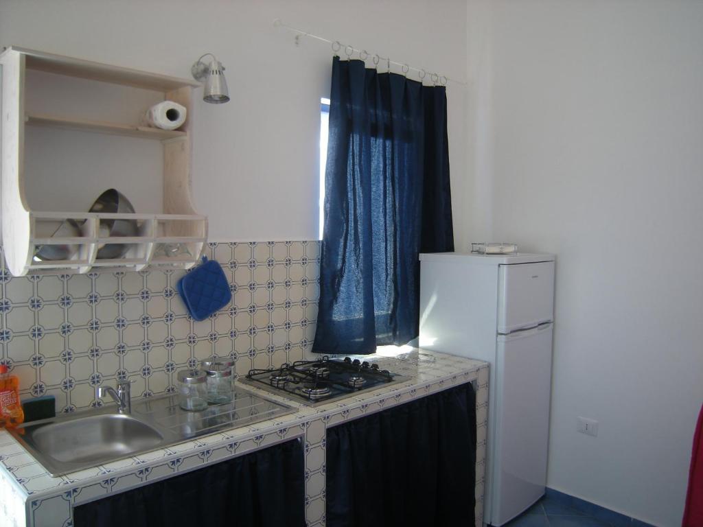 una piccola cucina con lavandino e frigorifero di Residence Timeo a Ustica