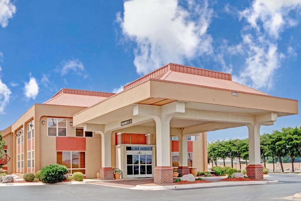 a large office building with a building at Ramada by Wyndham West Memphis in West Memphis